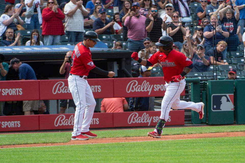 Cleveland Guardians' Jose Ramirez, right, is congratulated by third base coach Mike Sarbaugh after hitting a solo home run off Texas Rangers pitcher Cody Bradford in Cleveland on Sunday.