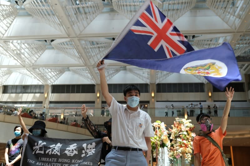 FILE PHOTO: A pro-democracy demonstrator waves the British colonial Hong Kong flag during a protest against new national security legislation in Hong Kong