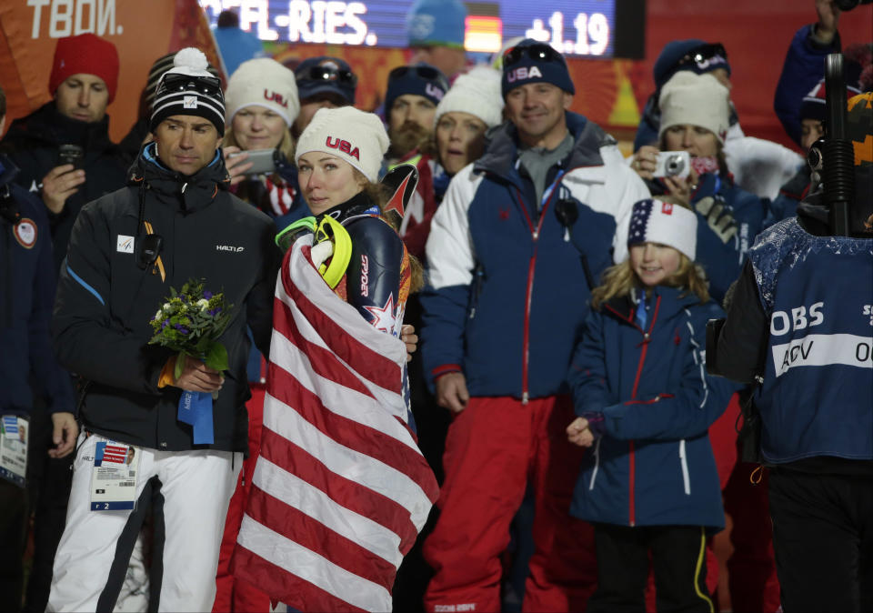 Women's slalom gold medal winner United States' Mikaela Shiffrin is draped in the American flag after a flower ceremony at the Sochi 2014 Winter Olympics, Friday, Feb. 21, 2014, in Krasnaya Polyana, Russia. (AP Photo/Gero Breloer)