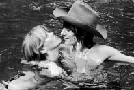<p>Rolling Stones guitarist Ron Wood and his first wife Krissy hang in their pool in Middlesex in 1975.</p>