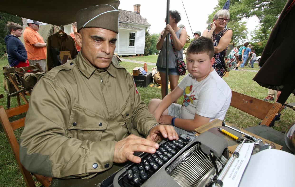 Paul Segarra types up the enlistment form of 10-year-old Bentley Parkus during Kings Mountain Historical Museum’s World War II Living History Day held Saturday, July 30, 2022, outside the museum on East Mountain Street in Kings Mountain.