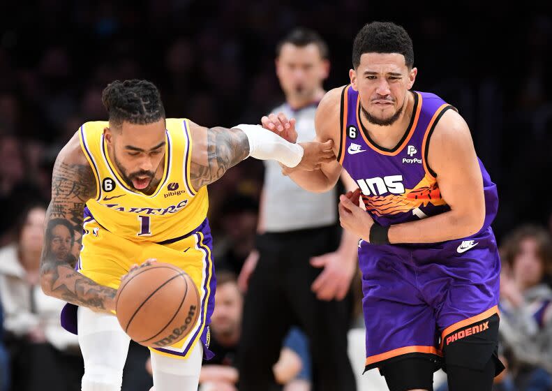 Los Angeles, California March 22, 2023-Lakers D'Angelo Russell steals the ball away from Suns Devin Booker in the fourth quarter at Crypto.com arena Wednesday. (Wally Skalij/Los Angeles Times)