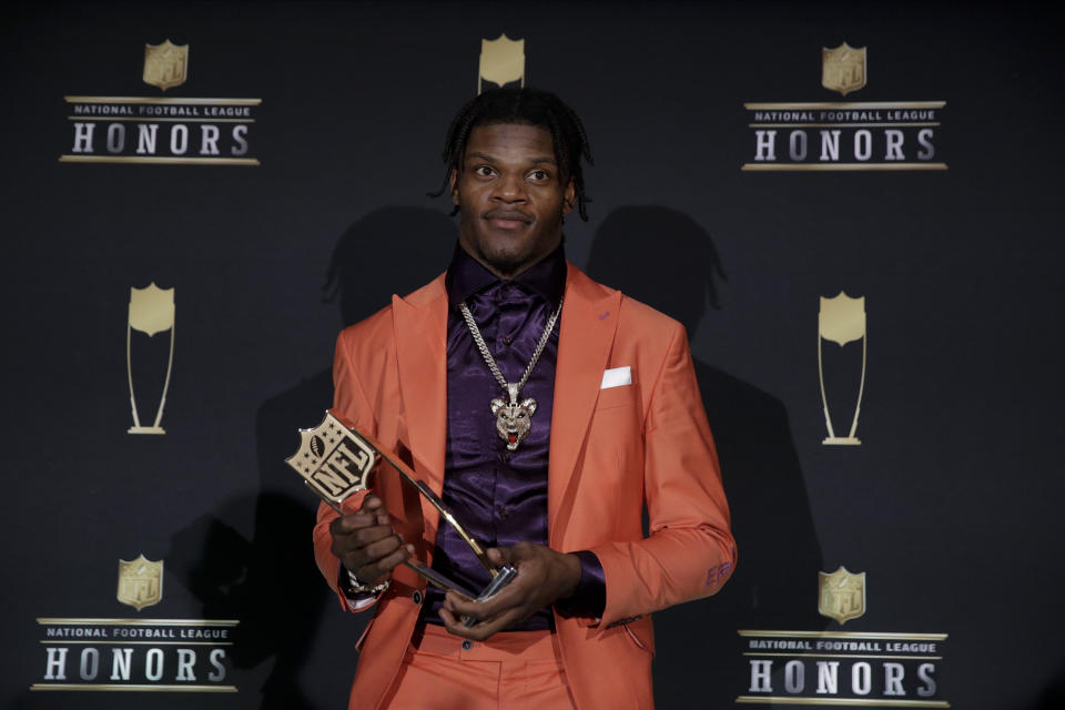 Lamar Jackson holds the AP Most Valuable Player award in front of an NFL Honors backdrop.