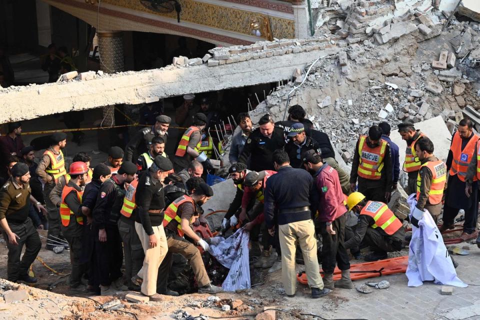 Rescue workers work to remove people from the rubble following the blast (AFP via Getty Images)