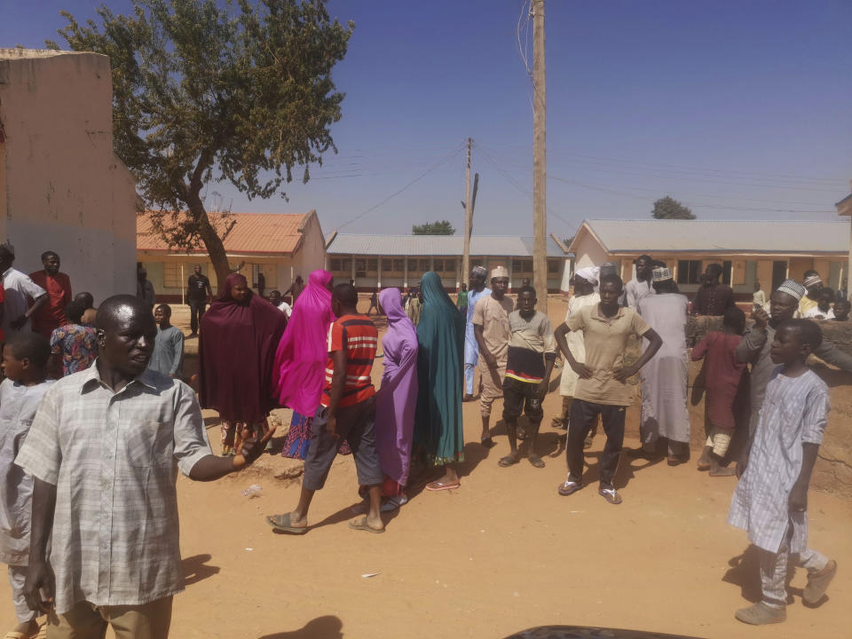 People stand outside Government Science Secondary School following the abductions.