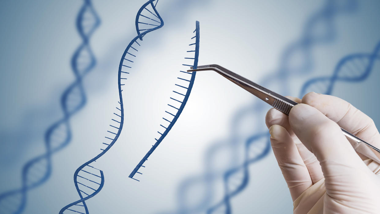  Close-up of a gloved hand using tweezers to pull genetic material from a suspended DNA molecule. 