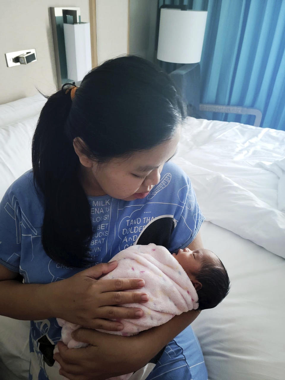 Blessy Argana holds her newborn in a hotel in Tumon, Guam on June 1, 2023. Many, including newborns, remain without electricity as Guam recovers from Typhoon Mawar (Ramil Argana via AP)