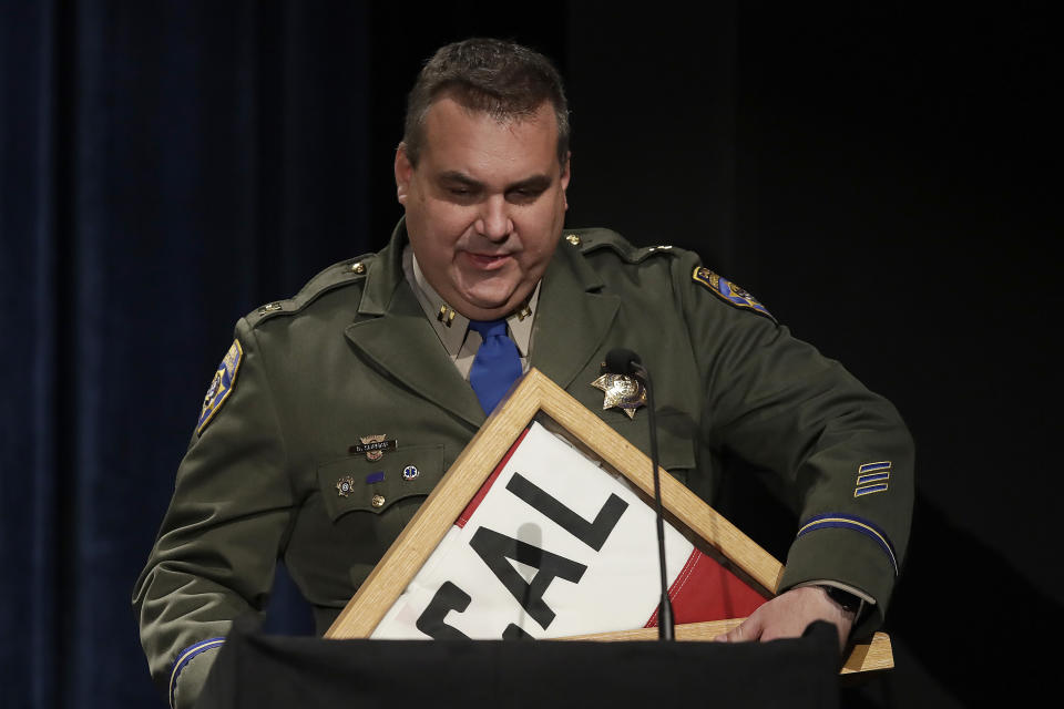 A California Highway Patrol officer holds a California flag brought at the request of California Gov. Gavin Newsom to present to Angela Underwood Jacobs, sister to slain Federal Protective Services Officer Dave Patrick Underwood, during a memorial service for Underwood on Friday, June 19, 2020, in Pinole, Calif. Underwood was fatally shot as he was guarding the Ronald V. Dellums Federal Building in Oakland, Calif., amid protests on May 29. (AP Photo/Ben Margot)