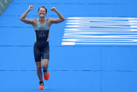 Flora Duffy of Team Bermuda celebrates as she approaches the finish line to win the gold medal during the women's individual triathlon competition at the 2020 Summer Olympics, Tuesday, July 27, 2021, in Tokyo, Japan. (AP Photo/David Goldman)