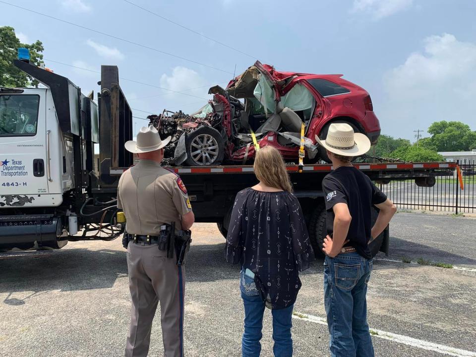 Sgt. Marc Couch of the Texas Department of Public Safety stands with Aspen Blessing's mother, Jennifer Blessing, and brother, Elijah Blessing, in front of Aspen's vehicle from a deadly crash, as part of the End the Streak Campaign to help end Texas highway fatalities.