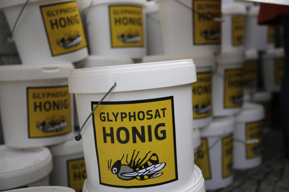 Plastic buckets with contaminated honey are piled up during a demonstration of beekeepers against the use of Glyphosate-based herbicides in farming in Berlin, Germany, Wednesday, Jan. 15, 2020. (AP Photo/Markus Schreiber)