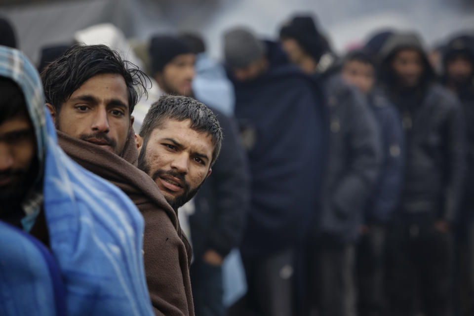 In this Sunday, Nov. 18, 2019 photo migrants wait in long lines for food distribution at a camp in Velika Kladusa, Bosnia, close to the border to Croatia. The approach of the tough Balkan winter spells tough times for the migrants that remain stuck in the region while trying to reach Western Europe, with hundreds of them staying in make-shift camps with no heating or facilities.(AP Photo/Amel Emric)