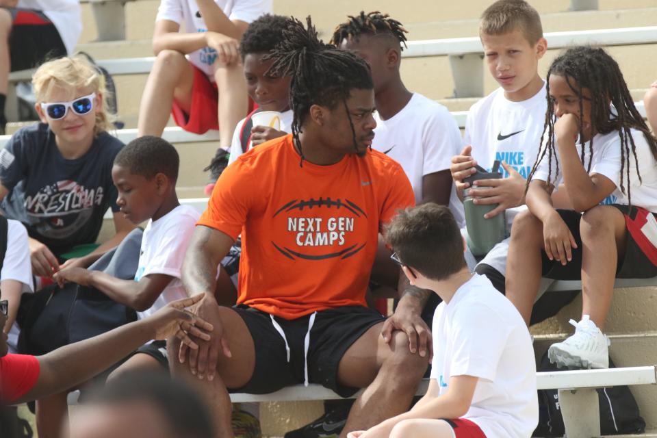 Former Mansfield Senior Tyger and current Michigan State Spartan Angelo Grose sits with a group of kids during the lunch break of the Nike Skills Football Camp to listen to the campers' football hopes and dreams.