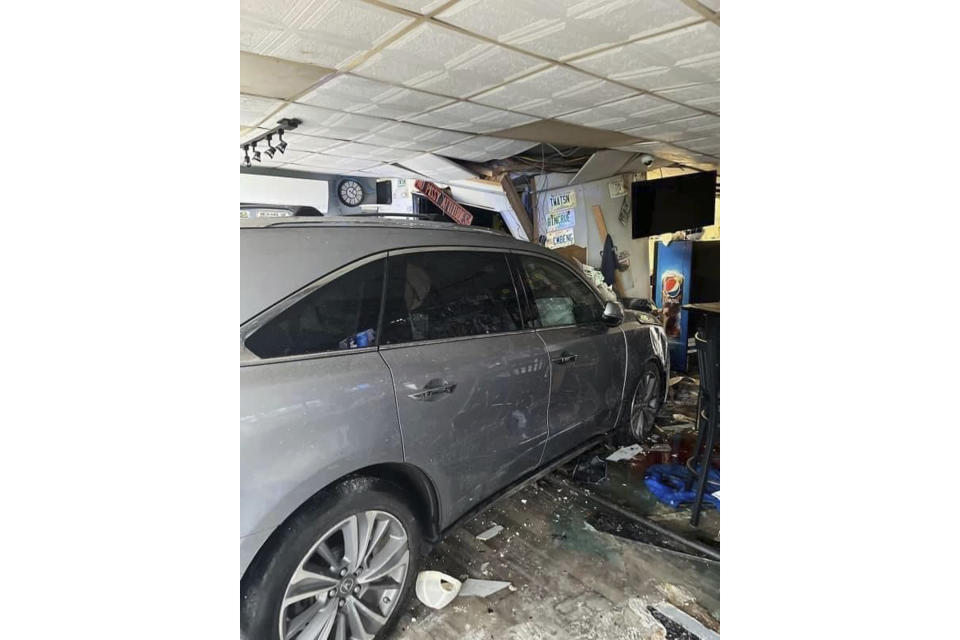 In this photo released by the Laconia Fire Department, a vehicle sits inside a restaurant after crashing through the wall on Sunday, July 2, 2023, in Laconia, NH. The car struck the busy Looney Bin Bar & Grill and injured more than a dozen patrons inside, authorities said. (Laconia Fire Department via AP)