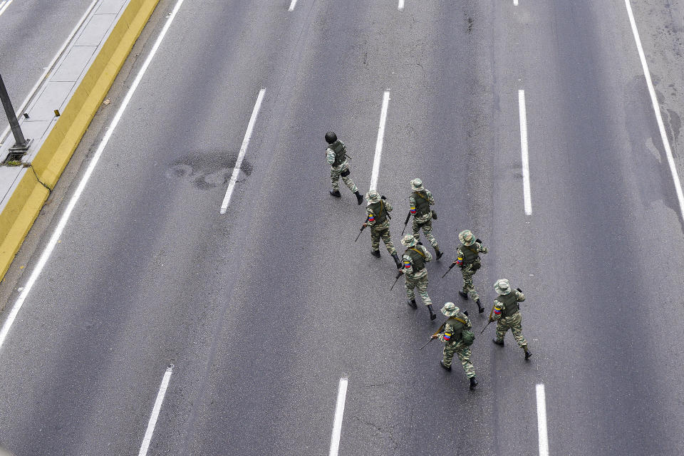 Military personnel crosses a highway during military drills in Caracas, Venezuela, Saturday, Feb. 15, 2020. Venezuela's President Nicolas Maduro ordered two days of nationwide military exercises, including the participation of civilian militias. (AP Photo/Matias Delacroix)