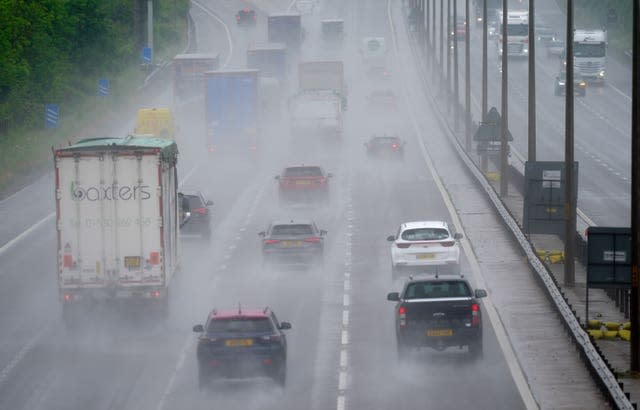 Cars on the motorway driving in rain. The spray makes it hard to see some of the cars in the distance