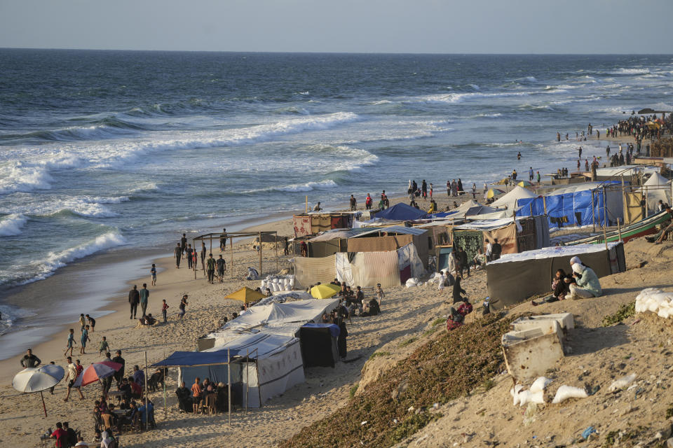 Palestinos desplazados por la ofensiva aérea y terrestre israelí caminan por una playa en el mar Mediterráneo en un campamento improvisado de carpas en Deir al Balah, el lunes 13 de mayo de 2024. Los palestinos conmemoraban el miércoles el 76to año desde su expulsión masiva de lo que ahora es Israel, un suceso en torno al que gira su lucha nacional. Pero en muchos aspectos, esa experiencia palidece en comparación con la calamidad que se produce ahora en Gaza. (AP Foto/Abdel Kareem Hana)