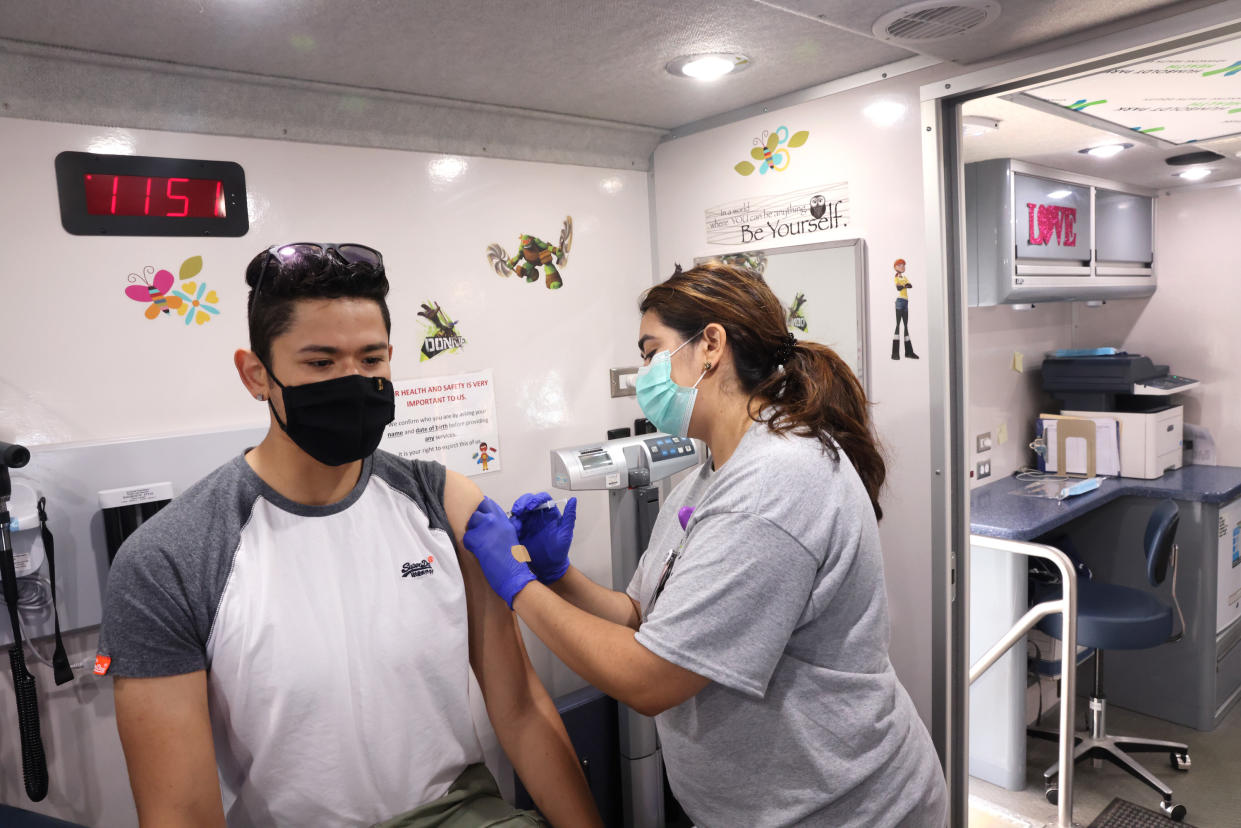 Francisco Huerta gets a COVID-19 vaccine from Tomasa Valencia at a mobile clinic being run by Humboldt Park Health on May 18, 2021, in Chicago, Illinois. The clinic partnered with two neighborhood restaurants. West Town Bakery and Roots Handmade Pizza, which closed their businesses for the day and used the space to help get their employees and neighborhood residents vaccinated. (Photo by Scott Olson/Getty Images)