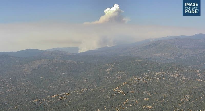 Smoke rises from hills as the Washburn Fire burns near Ahwahnee, California