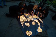 Lighting soya candles to create a candlelit WWF panda logo for Earth Hour 2011at Allan Gardens, Toronto, Ontario, Canada. <br> <a href="http://www.worldwildlife.org/sites/earthhour/index.html" rel="nofollow noopener" target="_blank" data-ylk="slk:For more information about Earth Hour 2012, visit WWF.;elm:context_link;itc:0;sec:content-canvas" class="link ">For more information about Earth Hour 2012, visit WWF.</a>