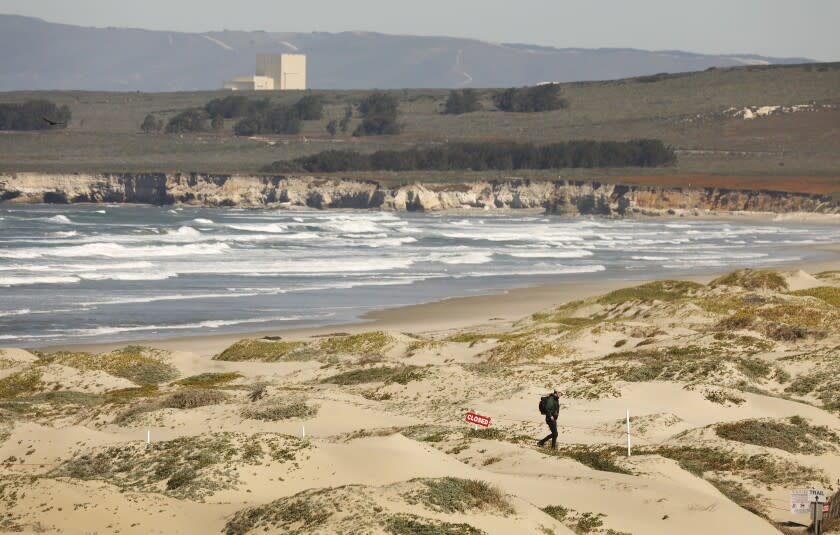 Lompoc, CA - March 07: Bart Vreeswijk, right, a beach keeper with the Vandenberg Space Force Base Center for Environmental Management of Military Lands walks the sandy dunes of Surf Beach where the nearby Santa Ynez River forms a estuary before it empties into the Pacific Ocean in Northern Santa Barbara County. Vreeswijk is monitoring the Snowy plovers, a bird species of special concern, which is scouting nesting sites at the water's edge. There is a controversial plan to build the first offshore wind energy facility in the western U.S. just west of Vandenberg Space Force Base in Lompoc. The companies behind this effort, which aim to have eight 300-foot-tall turbines floating only 2.5 miles off the coast by 2026, want to generate power for Vandenberg as well as gather data about potential environmental impacts that can be used to develop far larger federally-sponsored wind energy projects more than 20 miles offshore in decades to come. This is the same area where Chumash tribal members are working with NOAA to create a marine sanctuary. in Surf Beach on Monday, March 7, 2022 in Lompoc, CA. (Al Seib / For The Los Angeles Times)