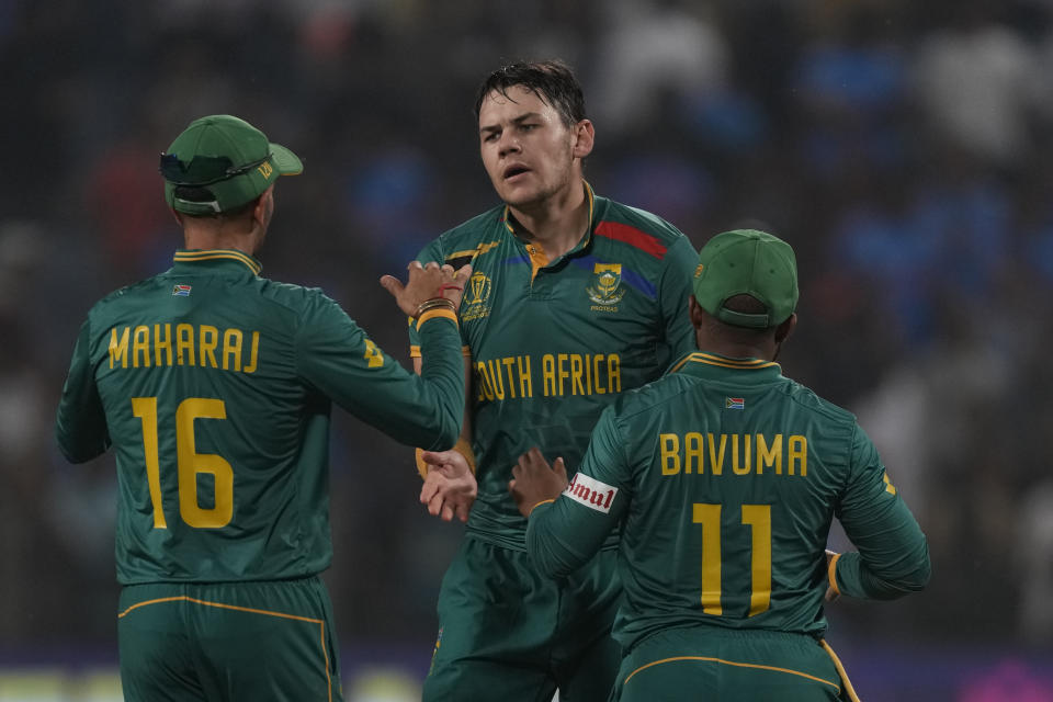 South Africa's Gerald Coetzee, centre, celebrates the wicket of New Zealand's Glenn Phillips with his team players during the ICC Men's Cricket World Cup match between New Zealand and South Africa in Pune, India, Wednesday, Nov.1, 2023. (AP Photo/Manish Swarup)