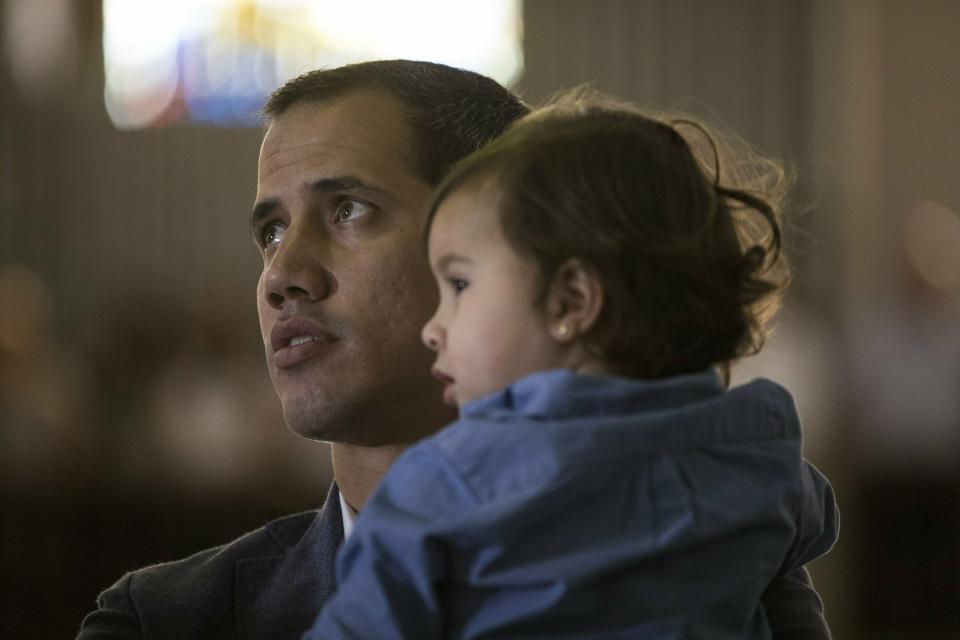 Opposition National Assembly President Juan Guaido, who declared himself interim president of Venezuela, holds his daughter Miranda while attending a Mass in a church in Caracas, Venezuela, Sunday, Feb. 10, 2019. (AP Photo/Rodrigo Abd)