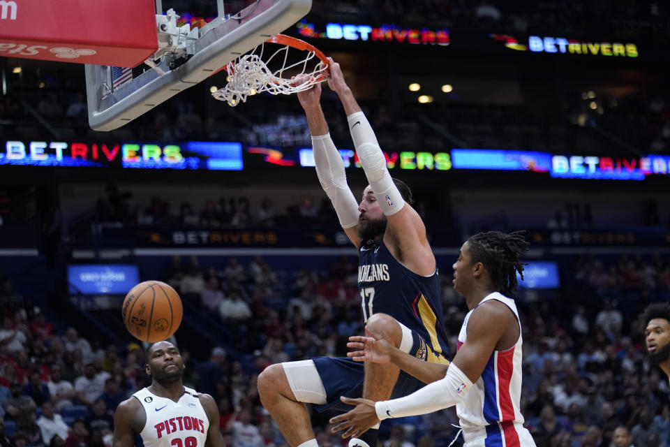 New Orleans Pelicans center Jonas Valanciunas (17) slam dunks over Detroit Pistons guard Jaden Ivey, right, and center Isaiah Stewart in the first half of an NBA basketball game in New Orleans, Wednesday, Dec. 7, 2022. (AP Photo/Gerald Herbert)