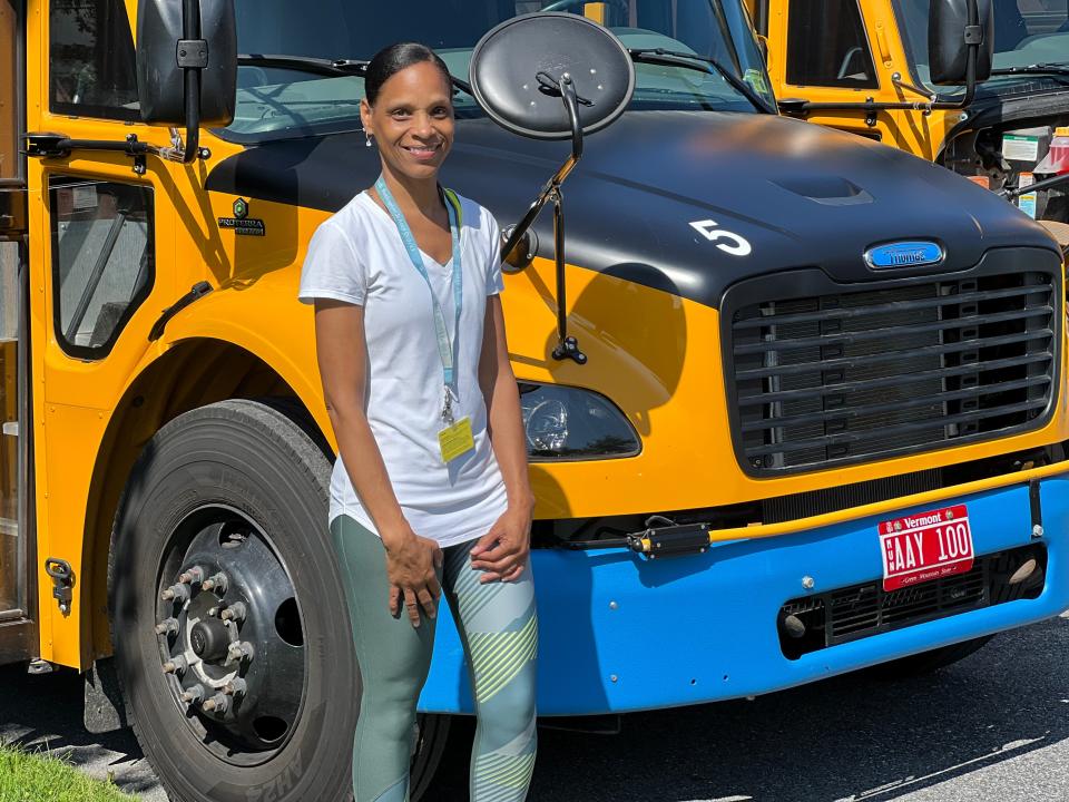 Cassandra Johnson, a seasoned bus driver, drove an electric school bus like the one behind her for a couple months right after she began working for the South Burlington School District the fall of 2022. She is seen in front of one of four of the district's electric buses on Aug. 28, 2023.