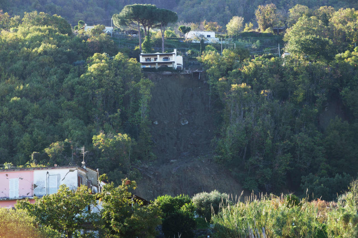 A photo shows houses on the edge of a landslide in Casamicciola on November 27, 2022, following heavy rains on the island of Ischia, southern Italy. - Italian rescuers were searching for a dozen missing people on the southern island of Ischia after a landslide killed at least one person, as the government scheduled an emergency meeting. A wave of mud and debris swept through the small town of Casamicciola Terme early Saturday morning, engulfing at least one house and sweeping cars down to the sea, local media and emergency services said. (Photo by Eliano IMPERATO / AFP)