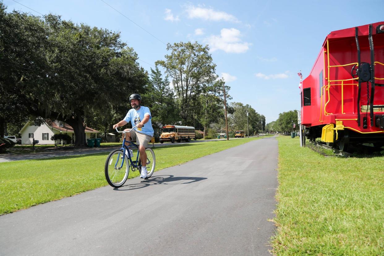 Guyton Mayor Russ Deen rides his bicycle along a trail in downtown Guyton.