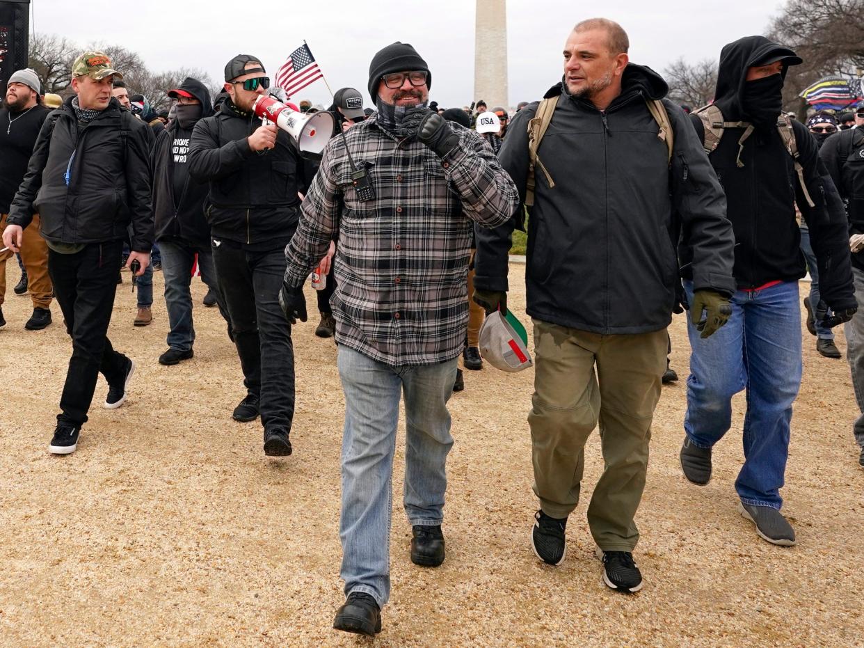 In this Jan. 6, 2021, photo, Proud Boys including Joseph Biggs, in flannel jacket, front left, walks toward the U.S. Capitol in Washington, in support of President Donald Trump. With the megaphone is Ethan Nordean, second from left.