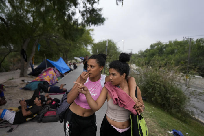 FILE - Venezuelan migrant women stand on the banks of the Rio Grande in Matamoros, Mexico, May 12, 2023, a day after pandemic-related asylum restrictions called Title 42 were lifted. Mexico is flying migrants south away from the U.S. border and busing new arrivals away from its boundary with Guatemala to relieve pressure on its border cities. (AP Photo/Fernando Llano)