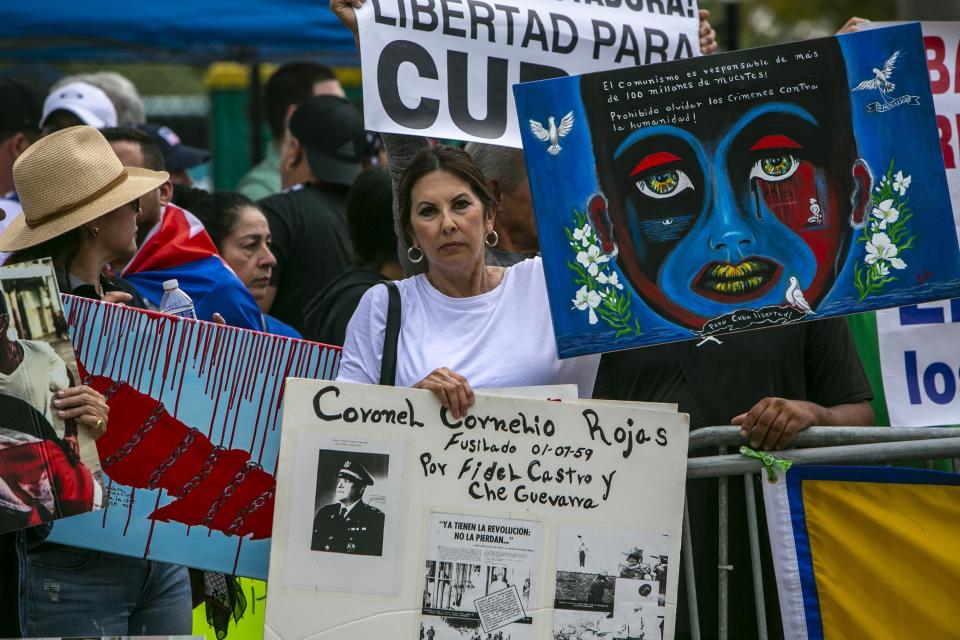 Demonstrators hold signs and shout slogans to protest at the baseball game between the United States and Cuba in front of LoanDepot Park prior to the baseball game, in Miami, Sunday, March 19, 2023. (Jose A. Iglesias/Miami Herald via AP)