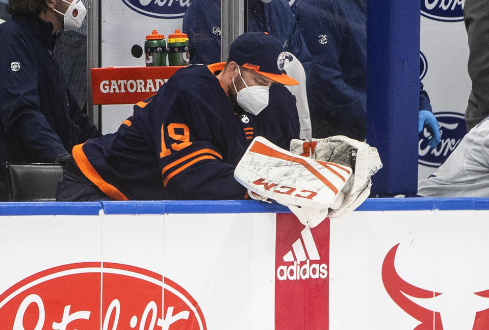 Edmonton Oilers goalie Mikko Koskinen (19) sits on the bench after being pulled for letting in four goals by the Vancouver Canucks during second-period NHL hockey game action in Edmonton, Alberta, Thursday, May 6, 2021.. (Jason Franson/The Canadian Press via AP)