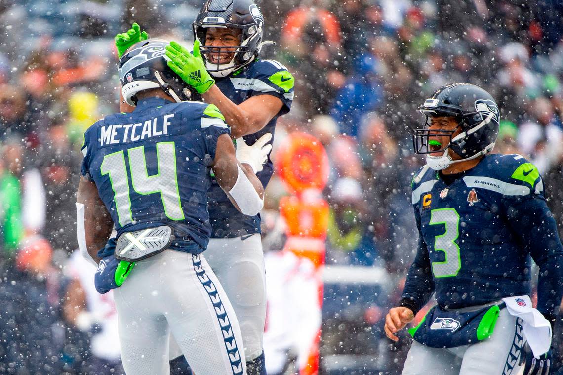 Seattle Seahawks wide receiver Tyler Lockett (16) and quarterback Russell Wilson (3) celebrate after wide receiver DK Metcalf (14) caught a touchdown pass from Wilson during the first quarter of an NFL game on Sunday afternoon at Lumen Field in Seattle.