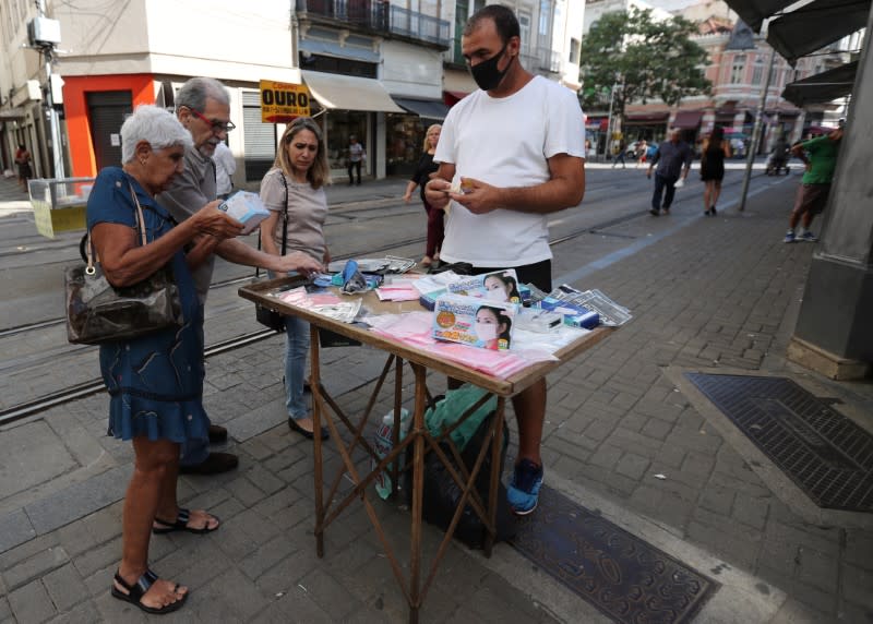 A street vendor sells protective masks after authorities announced measures to curb the spread of coronavirus disease (COVID-19), in downtown of Rio de Janeiro