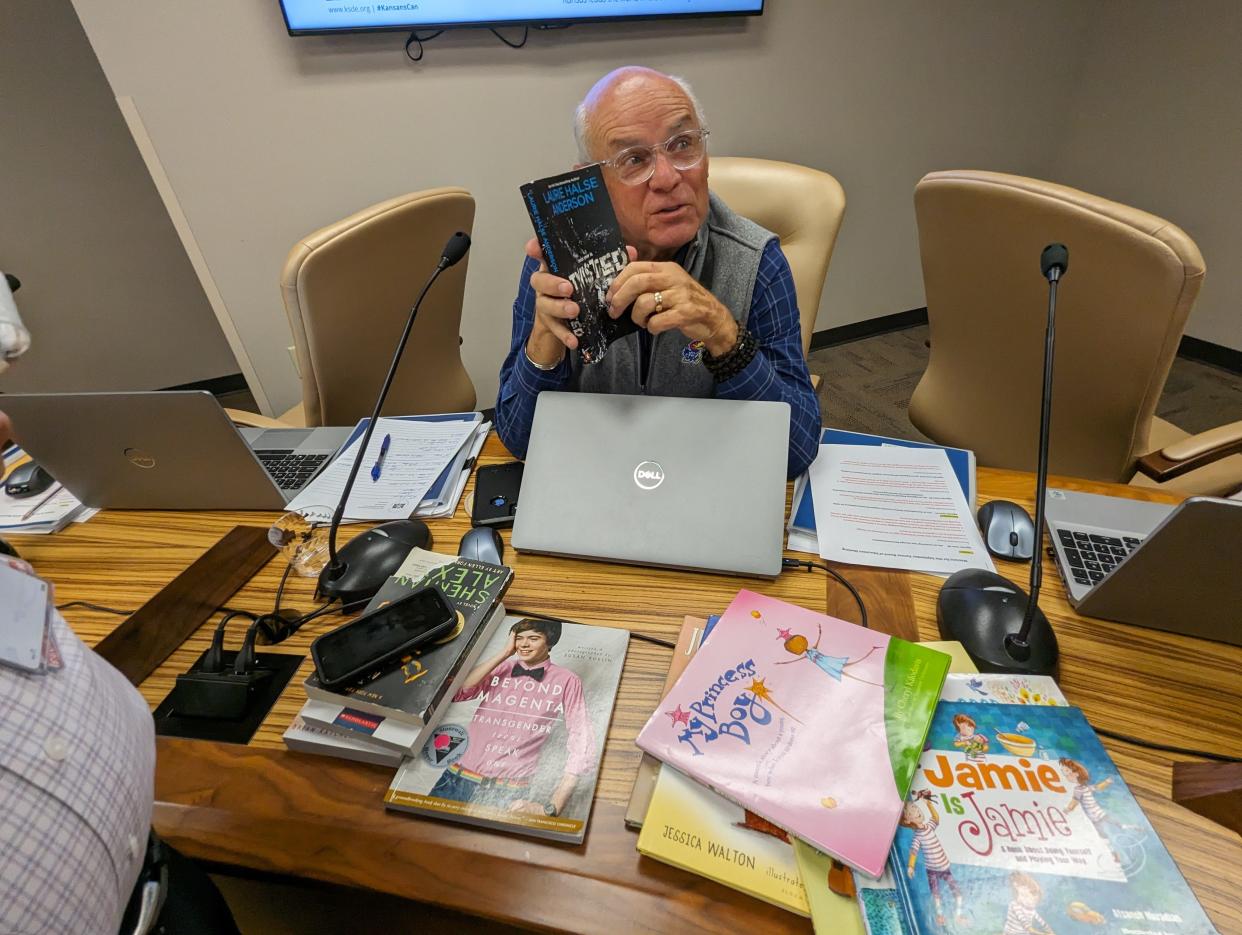 Danny Zeck, a Republican member of the Kansas State Board of Education from Leavenworth, shows reporters examples of the books he said parents have objected to in schools around Kansas.