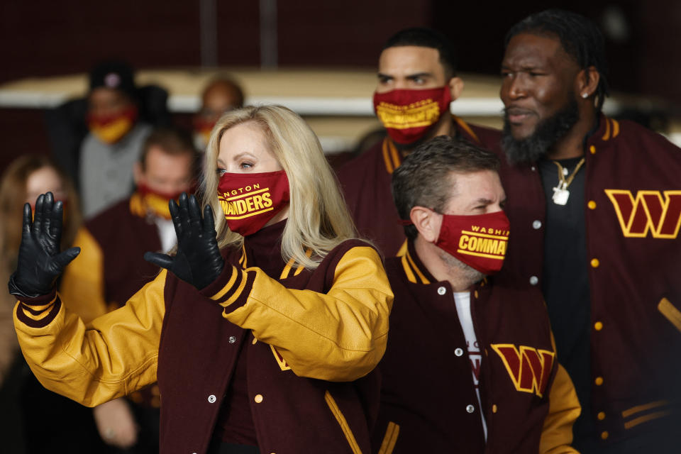 Feb 2, 2022; Landover, MD, USA; Co-owners Tanya Snyder (L) and Dan Snyder (M) walk in front of former players Jordan Reed (rear) and Brian Orakpo (R) to during a press conference revealing the Washington Commanders as the new name for the formerly named Washington Football Team at FedEx Field. Mandatory Credit: Geoff Burke-USA TODAY Sports