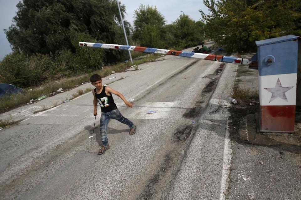 FILE - In this file photo dated Thursday, Sept. 17, 2015, a migrant child walks at the "Horgos 2" border crossing that leads into Hungary, from Horgos, Serbia, with the old Yugoslav communist flag on the abandoned border point. Europe’s open borders seem to symbolize liberty and forward thinking, but they increasingly look like the continent’s Achilles’ heel, with its inability to implement cross border security. (AP Photo/Darko Vojinovic, FILE)