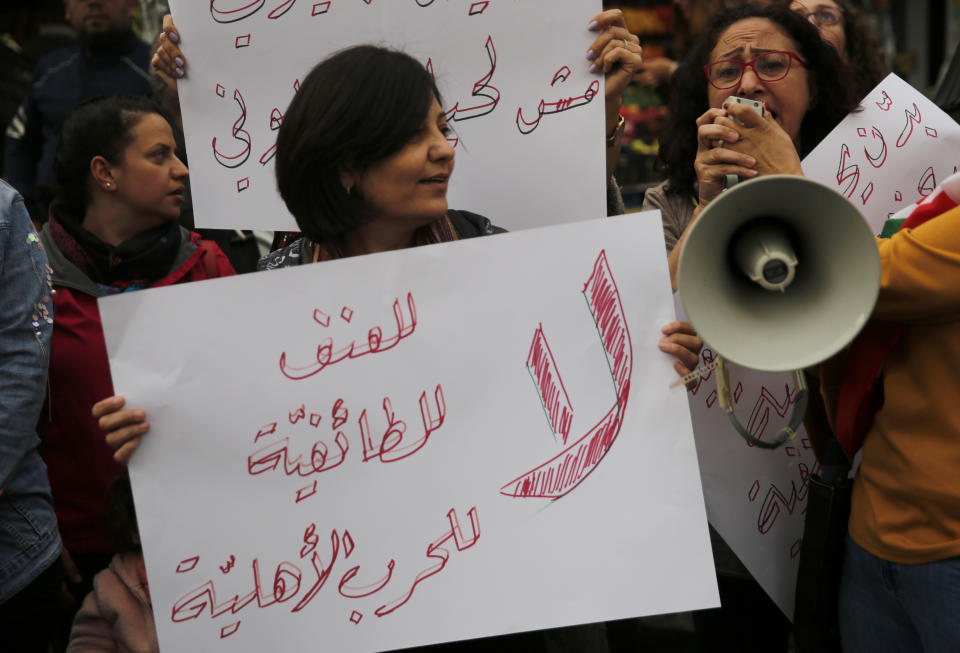 Lebanese women shout slogans, as they hold an Arabic placard that reads:"No to violence, no to sectarianism, no to civil war," during a protest at a former Beirut frontline between Christian district of Ain el-Rummaneh and a Muslim Shiite district of Shiyah, in Beirut, Lebanon, Wednesday, Nov. 27, 2019. Hundreds of Lebanese women marched across a former front line in the Lebanese capital carrying white roses and Lebanese flags to denounce overnight clashes between rival groups that injured dozens of people. (AP Photo/Hussein Malla)