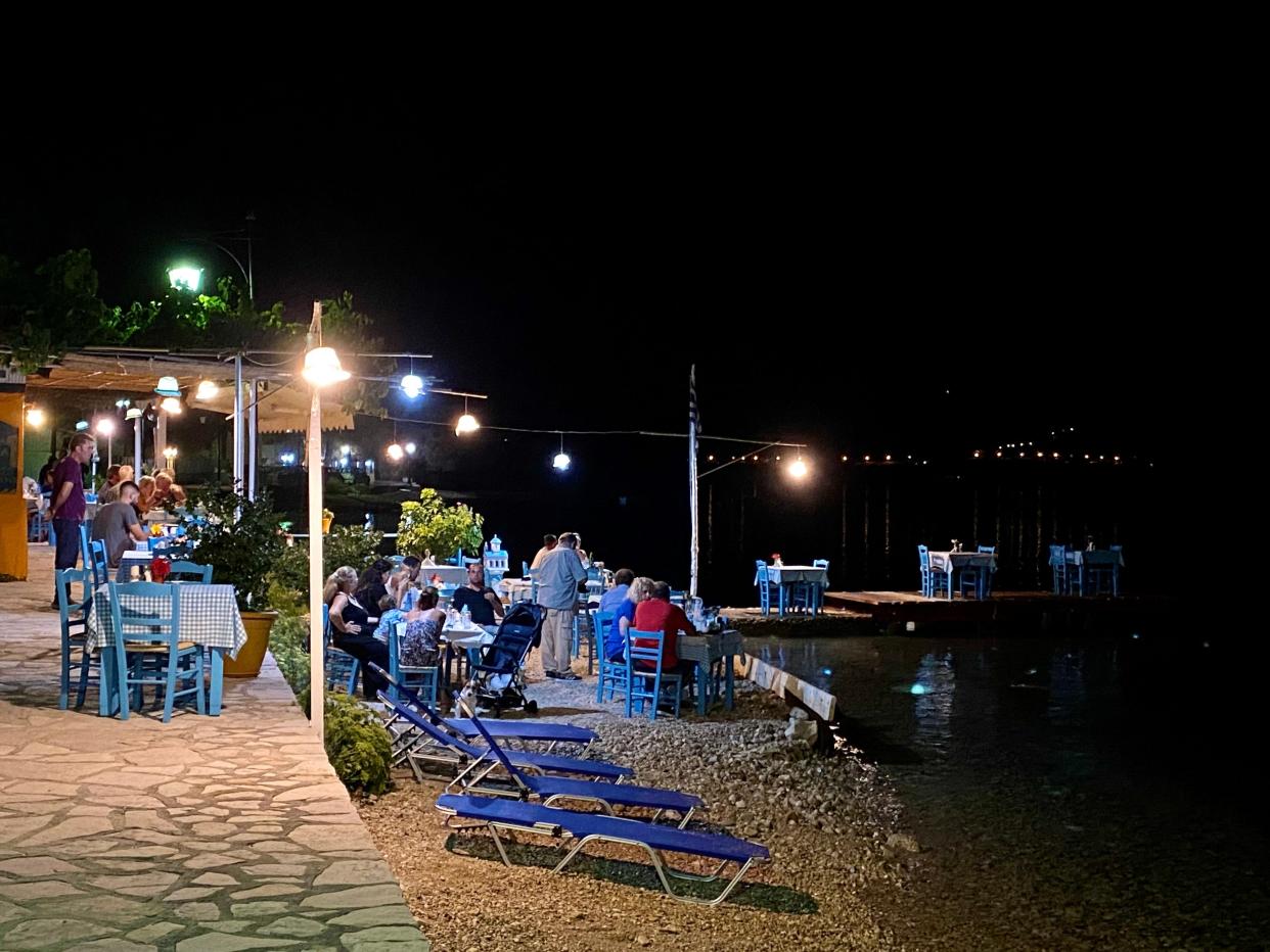 people sitting outside and eating at lefkada taverna in greece