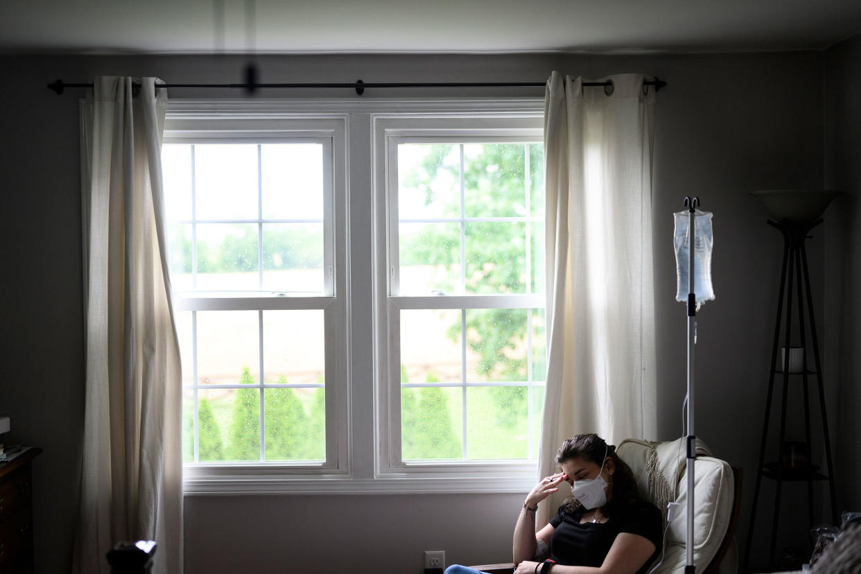 Mallory Stanislawczyk, a disabled former nurse practitioner who suffers from post-COVID POTs, gives herself a saline infusion through a PICC line in her Walkersville, Md. home on May 27, 2022.