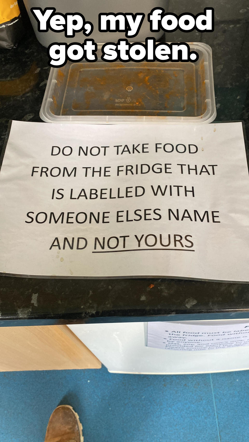 Sign in a fridge next to a plastic container top missing the bottom that reads, "DO NOT TAKE FOOD FROM THE FRIDGE THAT IS LABELLED WITH SOMEONE ELSES NAME AND NOT YOURS" with caption "Yep, my food got stolen"