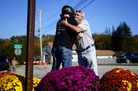 Richard Morlock, right, a member of the deaf community and surviver of the mass shooting at Schemengees Bar and Grille, embraces a person at a makeshift memorial in Lewiston, Maine, Saturday, Oct. 28, 2023. (AP Photo/Matt Rourke)