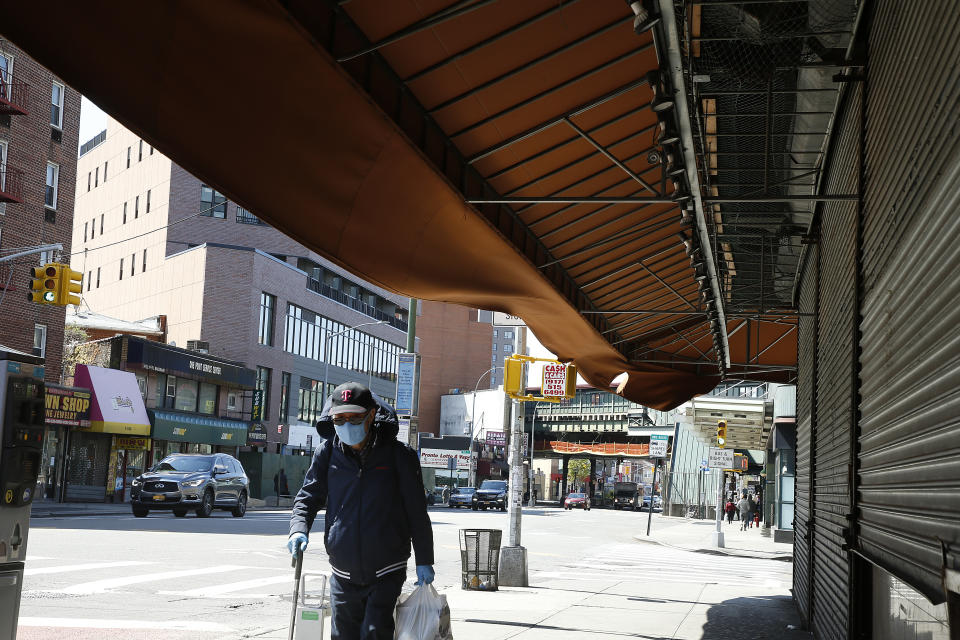 NEW YORK, NY APRIL 22:  A man wearing a protective mask walks past a closed store as major cities in the U.S. adjust to restrictive measures during the coronavirus pandemic on April 22, 2020 in Queens Borough in New York City. COVID-19 has spread to most countries around the world, claiming over 183,000 lives and infecting over 2.6 million people.  (Photo by John Lamparski/Getty Images)