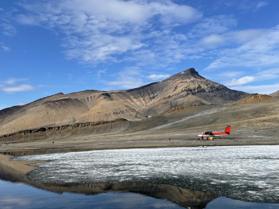 hills and sky in a landscape with a tiny propeller plane visible far in the background