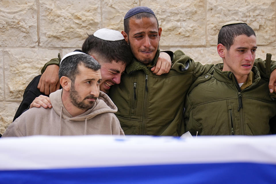 Friends of Sergeant Lavi Ghasi mourn during his funeral in Modiin, Israel,Thursday, Dec. 21, 2023. Ghasi ,19, was killed during the Israeli military's ground operation in the Gaza Strip. while the army is battling Palestinian militants in the war ignited by Hamas' Oct. 7 attack into Israel. (AP Photo/Ariel Schalit)