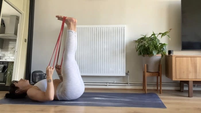 Writer Sam performing leg raises using resistance band during home ab workout