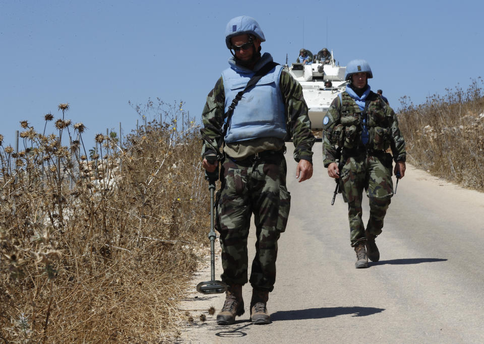 Irish UN peacekeepers use mine detectors as they patrol near the fields struck by Israeli army shells in the southern Lebanese-Israeli border village of Maroun el-Ras, Lebanon, Monday, Sept. 2, 2019. The Lebanon-Israel border was mostly calm with U.N. peacekeepers patrolling the border Monday, a day after the Lebanese militant Hezbollah group fired a barrage of anti-tank missiles into Israel, triggering Israeli artillery fire that lasted less than two hours and caused some fires. (AP Photo/Hussein Malla)